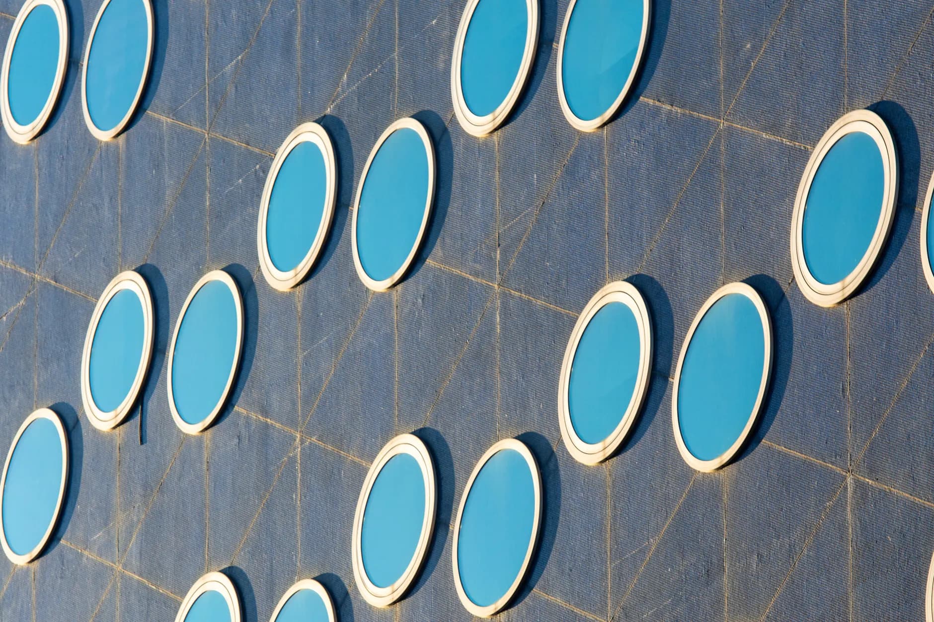 Close-up of a modern building facade featuring round blue windows for urban architecture enthusiasts.