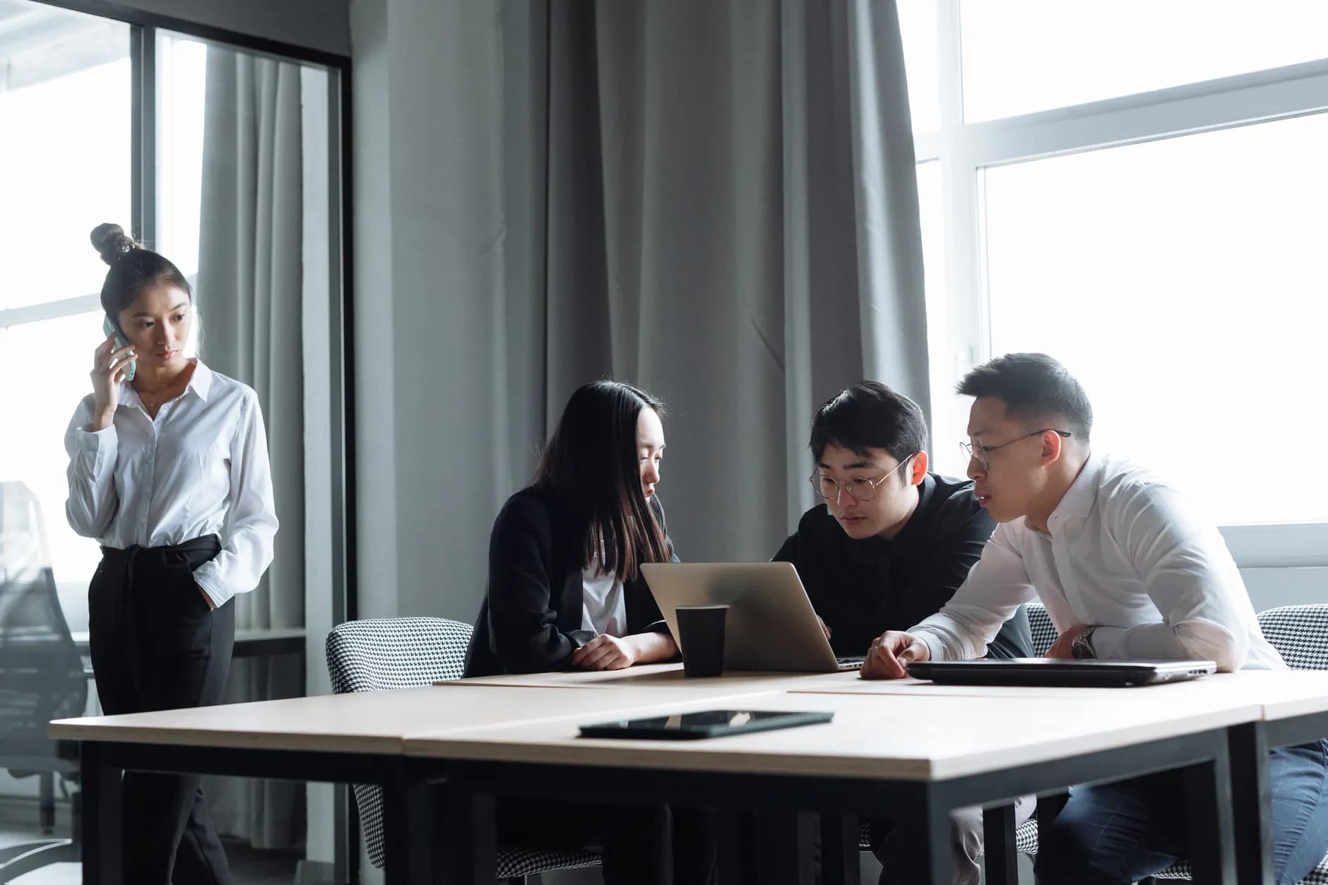 Diverse group of professionals collaborating on a project in a modern office environment.