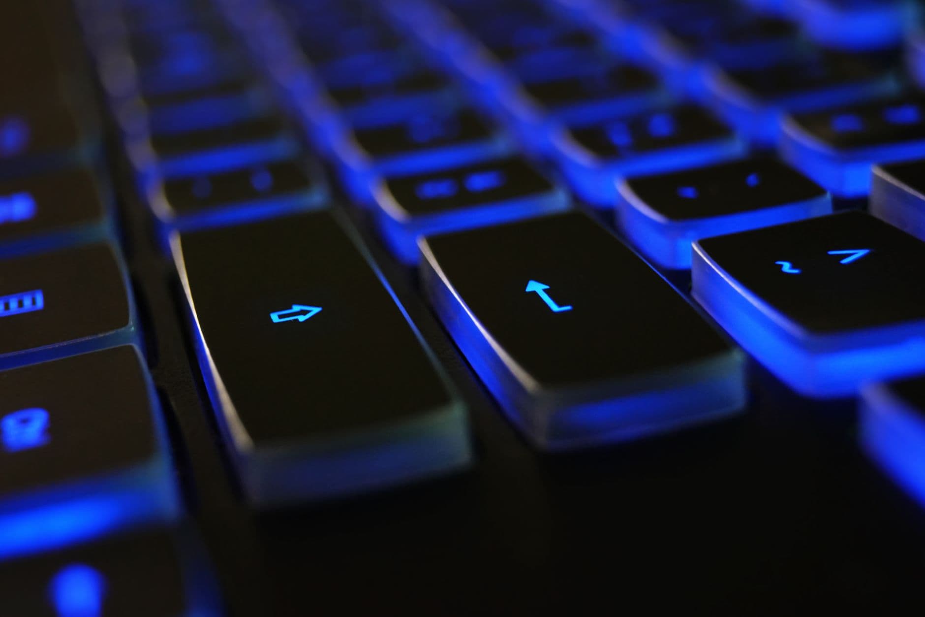 Detailed image of a computer keyboard with blue LED backlighting, highlighting keys.